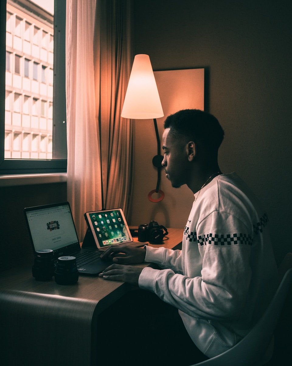 Photo by Collins Lesulie man using laptop inside room