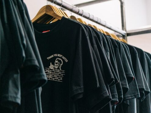 hanged black t-shirts beside wall